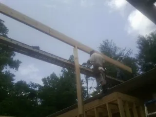 Carpenter setting a ridge beam over a new addition frame — Ice Dam Removal by Roofing Brothers in Twin Bridges