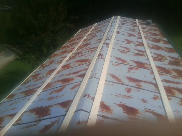 Rusted metal roof panels with new wood purlins before replacement — Storm Damage Roof Repair in Twin Bridges by Roofing Brothers