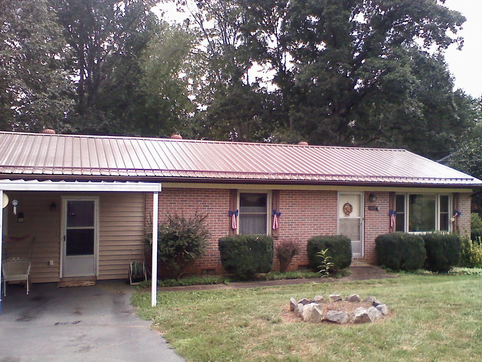 Bronze metal roof and carport on a brick ranch home — Roof Repair work by our crew in Twin Bridges