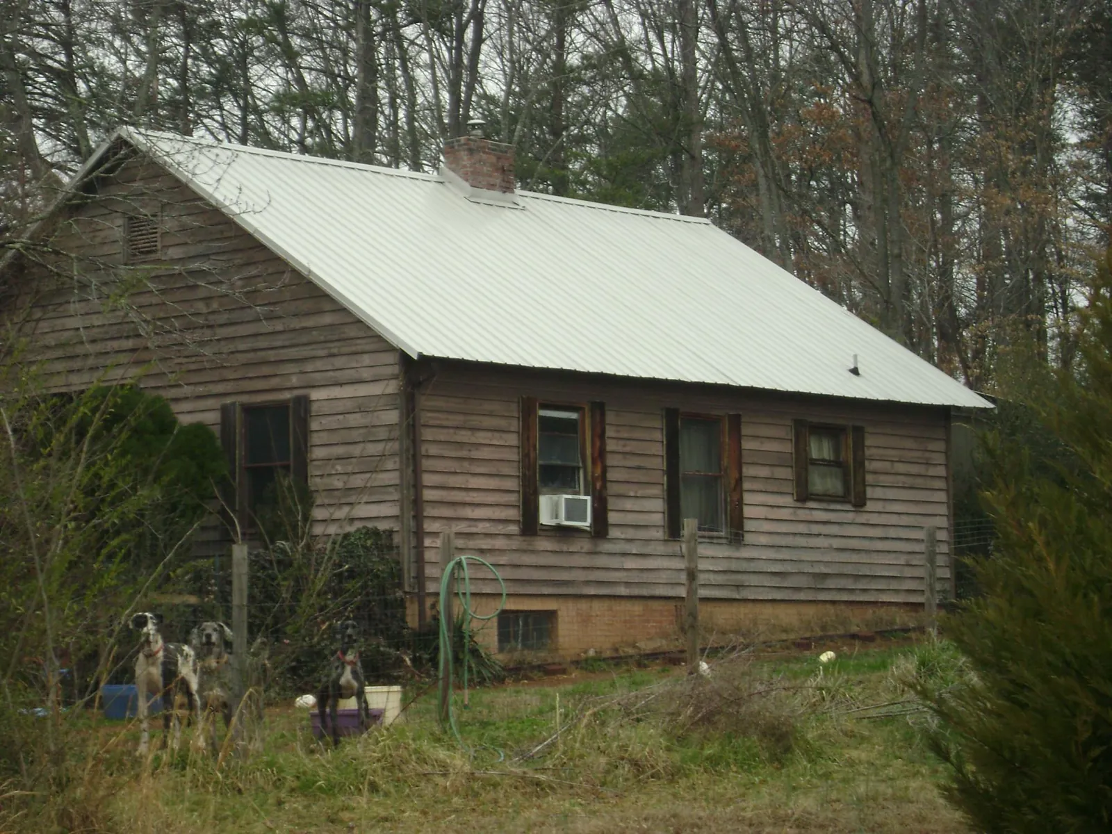 White metal roof on an old wood sided farmhouse, from a Metal Roof Installation job in Twin Bridges